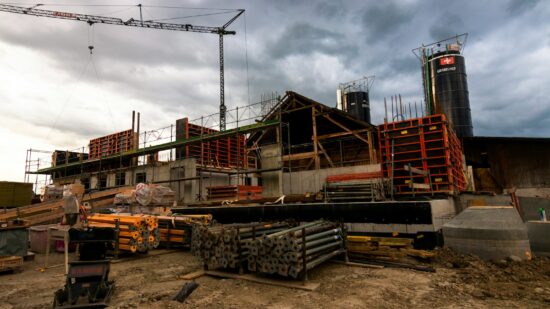 Panoramic view of building construction. Various pieces of form work, heaps of struts, scaffolding and other equipment.